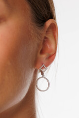 Beautiful young girl with fresh healthy skin. Woman advertise ear-rings. White background. Earrings, ear caffs closeup. Blond european woman with long hair with big lips, pretty smile. Cosmetology