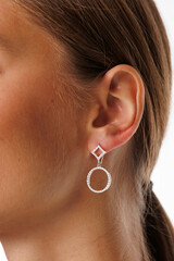 Beautiful young girl with fresh healthy skin. Woman advertise ear-rings. White background. Earrings, ear caffs closeup. Blond european woman with long hair with big lips, pretty smile. Cosmetology