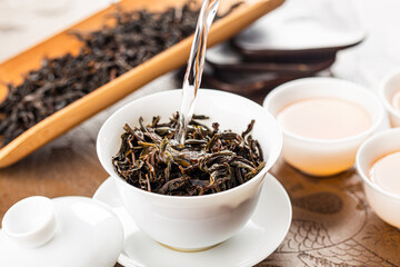 Brewing Chinese tea in ceramic gaiwan during the tea ceremony close-up.