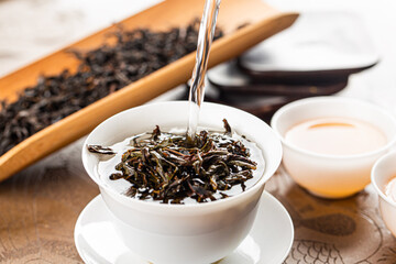 Brewing Chinese tea in ceramic gaiwan during the tea ceremony close-up.