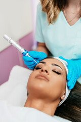 Professional cosmetologist making mesotherapy injection with dermapen on face for effective skin...