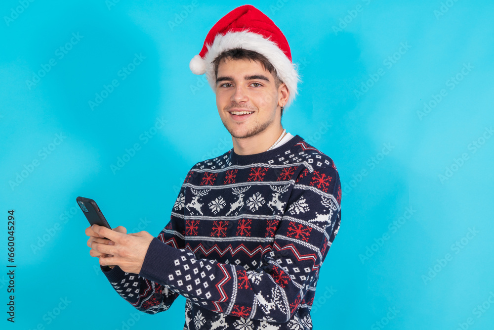 Poster young man with santa claus hat and mobile phone