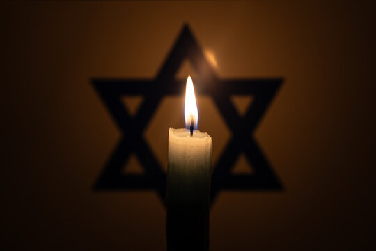 International Holocaust Remembrance Day, January 27. war in Middle East Burning candle on Israel flag background.