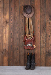 cowboy hat, boots and gun on a wooden floor - obrazy, fototapety, plakaty