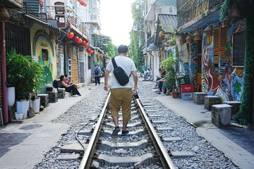 Man walking at Train Street in Hanoi, Vietnam - ベトナム ハノイ トレインストリートを歩く男性	 - obrazy, fototapety, plakaty