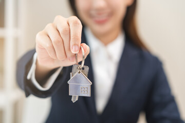 Close up hand of home, apartment agent, woman realtor  holding key to new landlord, tenant or rental after banker approved and signed on contract purchase agreement successfully. Property concept.