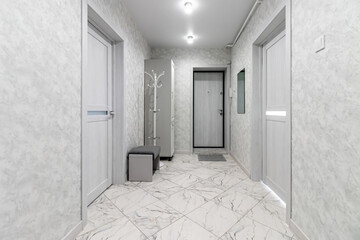 Empty gray hallway in contemporary living apartment without furniture and with closed doors