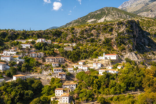 View of white houses with yellow shutters, moutains and sea. Vuno, Albania.