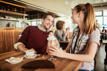 Young couple having coffee on a date in the cafe or bar