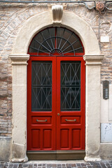 Old red wooden door. building's facade