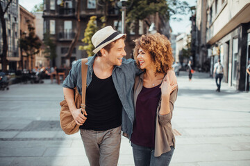 Young mixed couple embracing each other while having a stroll in the city