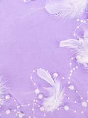 Soft lilac background with pearls and white down with a place for text