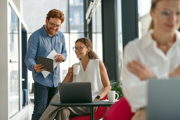 Male manager showing something on digital tablet to colleague during working day in office