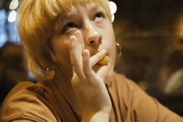 Teen girl eats delicious cheese sticks in a restaurant, enjoying.