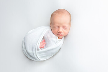 newborn baby wrapped in a cocoon. newborn baby on white background