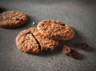 Oat cookies with raisins close-up on a gray background in the dark