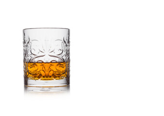Scotch whiskey in crystal elegant glass on white background with reflection.