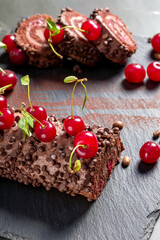 Chocolate roll cake with cream and cherries.