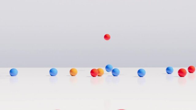 Zu Boden fallende, bunte Kugeln vor einem hellen wei&szlig;en Hintergrund