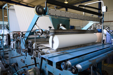 Greek factory for the production of paper rolls for hygiene. Manufacture of paper towels and toilet paper. Roll winding machine.
