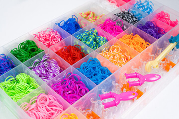 A set of multi-colored elastic bands for weaving bracelets for children.