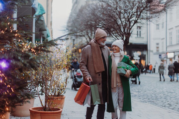 Happy senior couple buying christmas gifts in the city.
