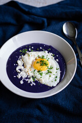 Purple potato soup with feta cheese and seeds
