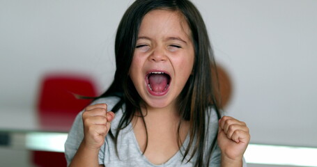 Upset little girl yelling feeling angry