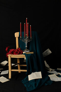 Romantic view with the candles, chandelier and a chair with black background