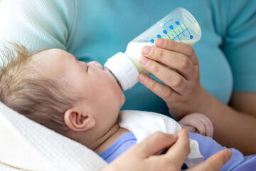 신생아를 안고 젖병으로 수유를하는 엄마