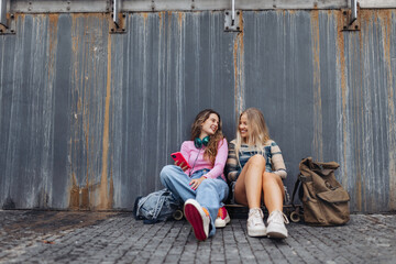 Young stylish generation Z girls spending time together outdoors after school. Zoomers talking and gossiping during lunch break in the school. Concept of power of friendship and importance of