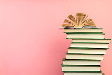 Open book, hardback books on wooden table, on a pink background. Back to school. Copy space for...