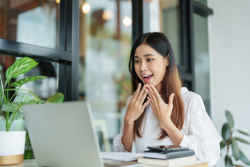 Writer woman read good news on laptop with happiness while working about business content in cafe