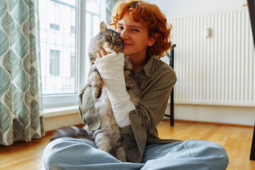 teenager with broken arm in cast and pet cat