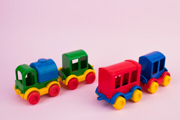 Children's toy, a multi-colored steam locomotive on a pink background.