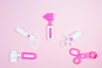 The concept of a pediatrician. Pediatrics. Toy medical devices on a pink background. Children play professional doctor. Choice of profession. Get vaccinated.