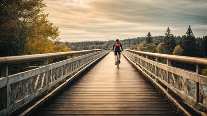 Tuinposter person riding bicycle on bridge © Aditya