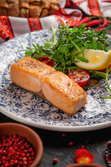 Fried trout fillet, served with arugula salad and cherry tomatoes