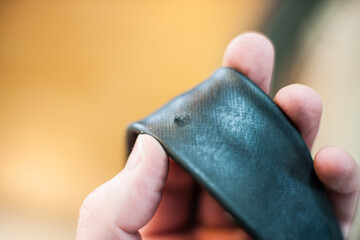 Obraz premium Hand holding a punctured bicycle inner tube.