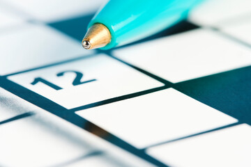 Ballpoint pen on background crosswords.