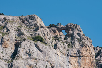 Fototapeta premium Hole in the limestone cliffs of the Archiane Cirque near Chatillon en Diois in the French Alps (Drome)