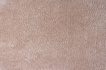 Terry cloth, beige towel texture background. Soft fluffy textile bath or beach towel material. Top view, close up.