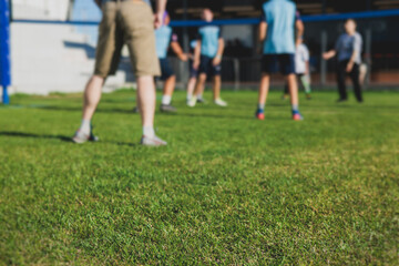 Volleyball game, junior teenage school team of kids play volleyball, players on the outdoor playground with net and green lawn grass court, sports children team during the game, summer sunny