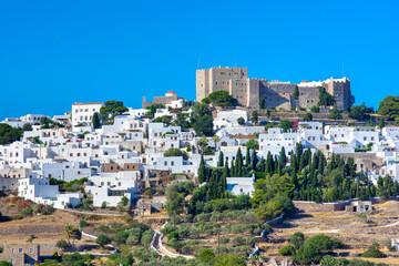 Obraz premium The three windmills of Chora and iconic Monastery of Saint John the Theologian in chora of Patmos island, Dodecanese, Greece