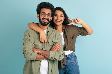 Cute happy young hindu couple posing together on colored background