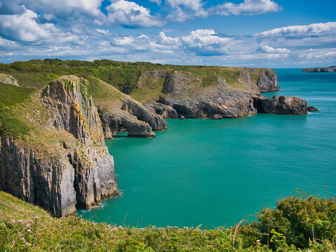 Coastal cliffs near Giltar Point in Pembrokeshire, Wales, UK - the vertically inclined rock strata of the limestone bedrock is of the Pembroke Limestone Group. Taken on a sunny day with a calm, sea. © Alan