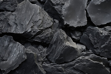Closeup of Basalt with a muted, dark color that appears almost charcoal in hue. Its texture is finely grained and appears to have a soft and velvety feel.