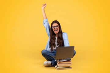 Excited student woman celebrates a win, joyfully looking at her laptop, isolated background
