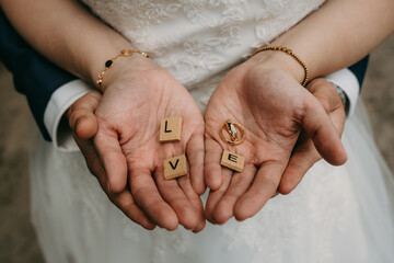 Hochzeit, Eheringe in Händen, LOVE Buchstaben