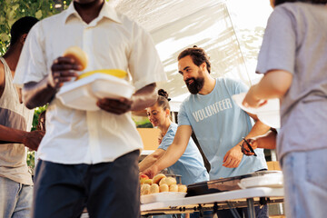 Friendly volunteers at food drive, busy sorting and packing food donations for distribution,...
